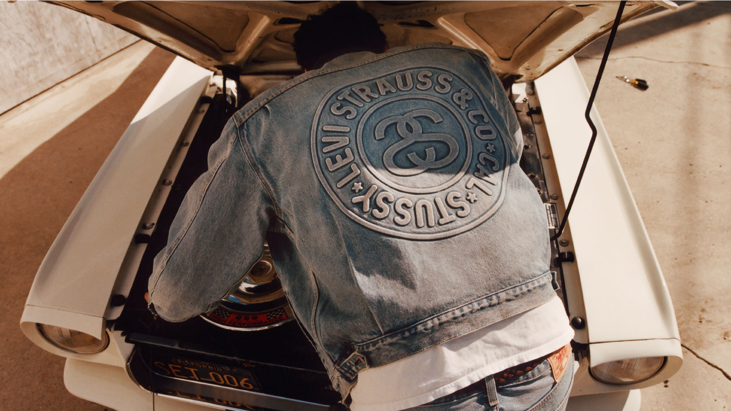 A man who styled in Stussy x Levi's denim jacket is repairing his car - Levi's Hong Kong